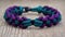 a close up of a bracelet on a wooden surface with a knot on it\\\'s end and a knot on the end of the end of the bracelet