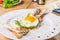 Close up Breakfast with fried eggs, toasts and meat pate on white plate on the served wooden table. Selective focus, copy space