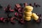 Close-up of breakfast morning with yellow macaroons lemon taste. close-up of french dessert on the black background and flowers