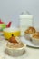 Close-up of a breakfast: three muffins, a cup, a teapot and a jar with sugar.