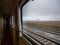 CLOSE UP: Breathtaking vista through window of train passing by snowy mountains