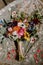 Close-up of a bridal bouquet of resting on a white wedding veil with intricate embroidery