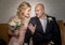 Close up of bride and groom in vintage clothing sitting and touching and talking