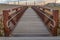 Close up of a bridge with a wooden deck and brown metal guardrails