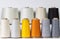 Close-up of bright colored bobbins with threads standing in two rows on a white isolated background. Garment production
