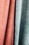 Close-up bright pink and blue curtains in thin and thick vertical folds of dense fabric. Textured abstract backgrounds and