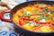 close-up of bright red and yellow peppers in shakshuka