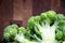 Close-up broccoli inflorescences on wooden blurred background with copy space. Top view. Selectiv focus. Fresh head of broccoli