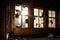 close-up of broken windows in abandoned building, with eerie light shining through