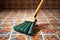 close-up of broom bristles sweeping a tiled floor