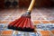 close-up of a broom bristles on a tiled floor