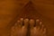 Close up of a brown asian feet,  on a brown wooden background  with Mortons toe.