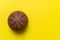 Close up of brown basketball ball isolated on yellow. Sport team concept. Top view, space for your text