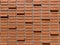 Close up of brown brick wall, some brick are protrude