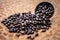 Close up of brown colored dried custard apples or sitaphal or sugar apple seeds in a black colored clay bowl on a brown colored su