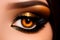 Close up on a brown woman\\\'s eye with a golden make-up.