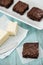 Close Up of Brownies Set On a Plate and a Stick of Butter