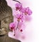 Close up of Buddha head and orchid