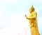 Close-up of the Buddha image with a beautiful yellow aura in the outdoor Thai temple.  Sky background