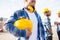 Close up of builder holding hardhat at building