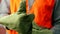 Close-up of a builder`s hand in a protective glove gesturing a sign okay. Worker in overalls shows thumbs up. Construction site. J