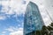 Close-up on a building with mirrored windows which reflects a blue sky with clouds. Business and construction