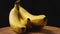 A close-up of a bunch of ripe yellow bananas on a wooden surface spins against a dark background. The camera flies