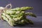 Close-up of a bundle of asparagus tied with twine on a gray slate surface