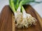 Close-up of bundle of spring onions laying on wooden board