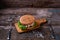 Close Up of Burger Piled High with Fresh Toppings on Whole Grain Artisan Bun, on Rustic Wooden Surface with Dark Background and Co