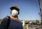 Close up of burnette woman  wearing face mask with baseball cap in store parking lot