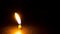 Close-up of burning candle on black background. Time lapse, looping