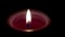 Close up on a burning candle on a dark background.