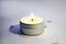 Close-up of a burning candle spreading fragrance on a table. Beautiful composition with massage candles for relaxation