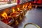 Close up of burning candles inside golden goblets in a temple. Kathmandu, Nepal, Asia