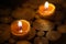 Close-up of burning tealight candle on table in home