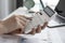 A close-up of a business finance woman`s hand pressing a white calculator to calculate numbers from company financial documents.