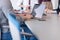 close up of business man hands typing on laptop with team on meeting in background