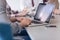 close up of business man hands typing on laptop with team on meeting in background