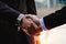 Close up of business man in suit shaking hands after finishing up a business meeting in city with during sunrise