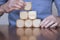 Close up of a business person arranging large wooden blocks. Business strategy and solutions