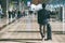 Close up of businessman carrying suitcase while walking through a passenger departure terminal in airport. Businessman traveler