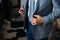 Close-up businessman groom wearing his blue checkered jacket at the morning of wedding day. Concept of men stylish