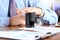 Close-up of businessman hand pressing a stamp on document in the office