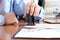 Close-up of businessman hand pressing a stamp on document in the office