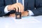 Close-up Of Businessman Hand Pressing a Stamp On Document in the office