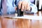 Close-up Of Businessman Hand Pressing a Stamp On Document in the office