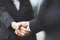 Close up of a businessman hand shake businesswoman between two colleagues