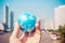 Close up of businessman hand showing a small model globe and city