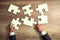 Close-up of businessman hands try to completing jigsaw puzzle